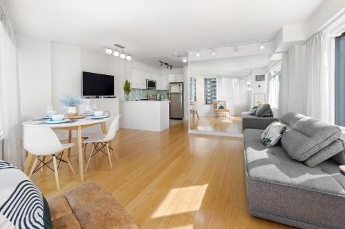多伦多Modern 2-Bedroom Condo w Floor to Ceiling Windows的客厅配有沙发和桌子