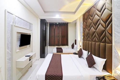 新德里Hotel Qubic Stay Near Delhi Airport的酒店客房设有一张大床和一台电视机。