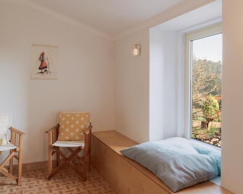 维拉·普拉亚·德·安科拉Quinta da Quinhas的卧室配有床、椅子和窗户。