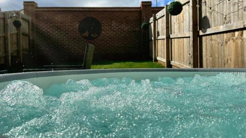 韦克菲尔德Leeds getaway with hot tub & gaming room的后院里装满水的浴缸