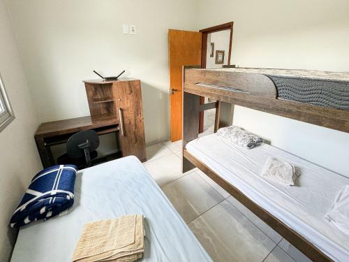 帕图斯迪米纳斯207- APARTAMENTO de 2 QUARTOS no ALTO CAIÇARAS的客房设有两张双层床和一张书桌。