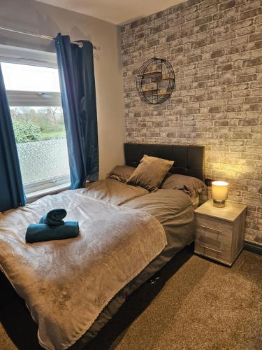 莱斯特Tudor Road House的一间卧室设有一张床和砖墙