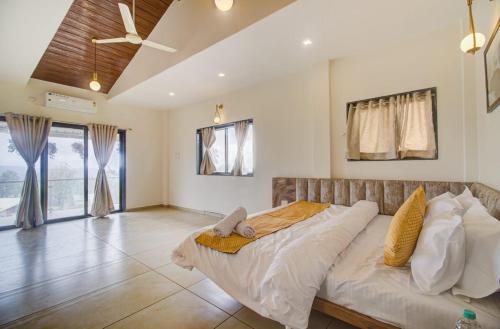 马哈巴莱斯赫瓦尔OCEAN CREST LUXURY VILLA Mahabaleshwar的一间带一张大床的卧室,位于带天花板的房间内