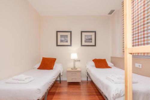 巴塞罗那瑟瑞尼亚赛斯特亚克德特欧姆公寓的白色墙壁客房中的两张单人床