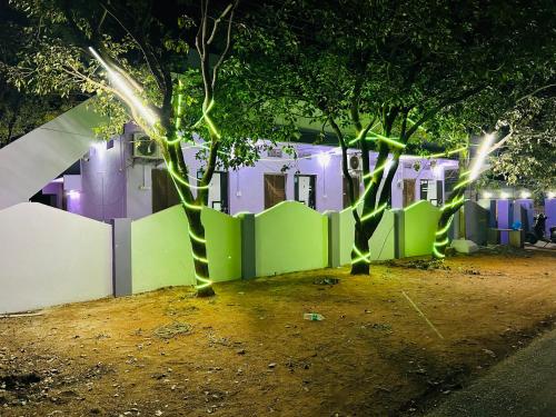SrīsailamHotel R residence的两棵树在晚上围栏前