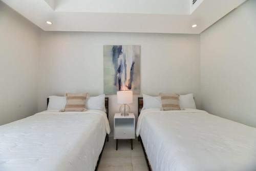 西湾Marlin Villa #10的白色墙壁客房的两张床
