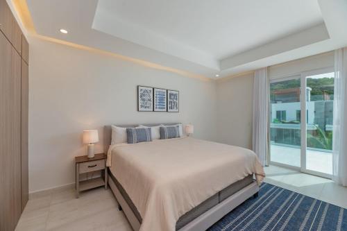 西湾Marlin Villa #10的白色的卧室设有一张大床和一个窗户