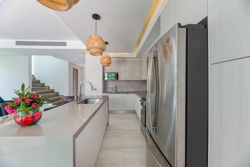 西湾Marlin Villa #10的厨房配有白色橱柜和不锈钢冰箱