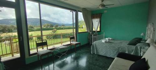 NavahermosaCasa Rural Finca Los Pajaros Montes de Toledo的一间卧室配有一张床,享有田野美景