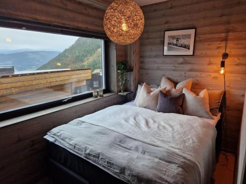 斯屈勒斯塔穆Ny, eksklusiv hytte til leie på Voss的一间卧室设有一张床和一个大窗户