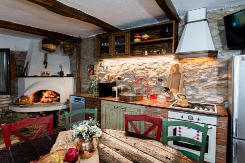丘斯滕迪尔Вила Китна的厨房配有桌子和壁炉。