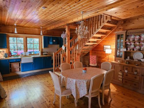 百利科内尔Forest Lodge Log Cabin - Ireland的厨房以及带桌椅的用餐室。