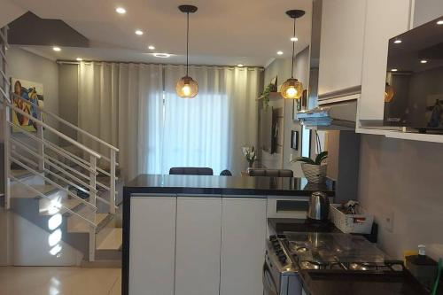 布卢梅瑙Casa linda, luxo e aconchegante的厨房配有白色橱柜和台面