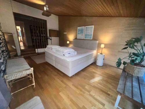 赫尔湾Cozy house near the sea的卧室配有一张白色的大床,铺有木地板