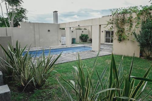 萨尔塔Sarmiento Suites Premium的庭院中带游泳池的房子