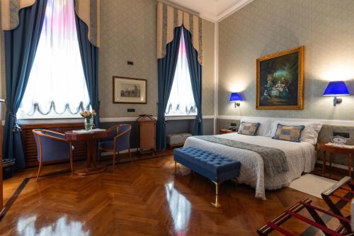锡拉库扎奥提伽大酒店的一间卧室配有一张特大号床和一张桌子