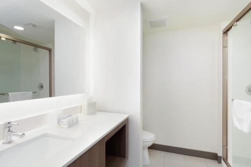 凤凰城Holiday Inn & Suites Phoenix Airport, an IHG Hotel的白色的浴室设有水槽和卫生间。