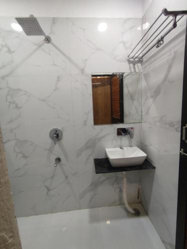 乌贾因The prime hotel的白色的浴室设有水槽和淋浴。