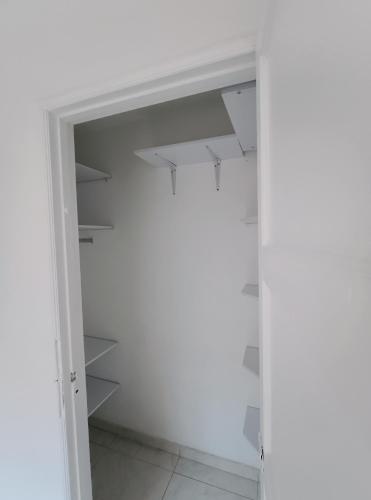 波哥大Casa portón negro的配有白色墙壁和架子的步入式衣柜