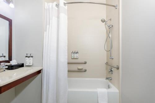 杰克逊维尔Holiday Inn Express Hotel & Suites Jacksonville - Mayport / Beach, an IHG Hotel的带淋浴和盥洗盆的白色浴室