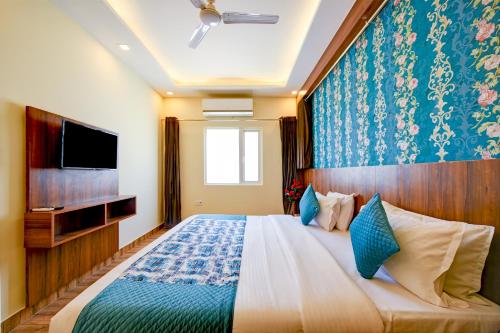 新德里Roseewood Hotel Near Delhi International Airport的一间带大床和电视的卧室