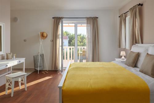 RudinaDoris Hvar的一间卧室配有黄色的床和一张书桌,还设有一个阳台