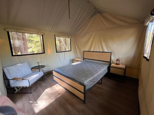卡梅尔瓦利The Camp at Carmel Valley的一间卧室配有一张床铺,帐篷内提供一把椅子