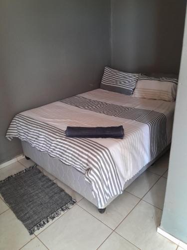 BochumLetz Guest Lodge的卧室内的一张床位,配有黑色和白色的毯子