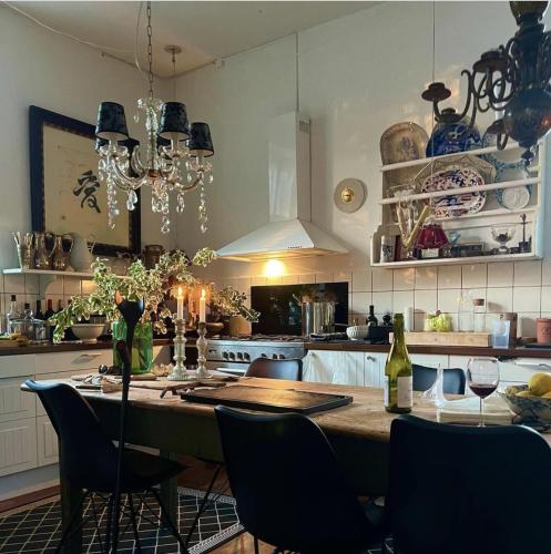 普赖斯特Jungshovedgaard Bed & Breakfast的厨房配有带椅子的大木桌和餐桌,提供糕点