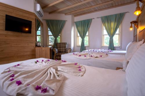 博德鲁姆Museum Resort Spa的酒店客房,配有两张带鲜花的床