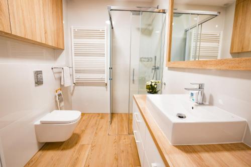 济夫努夫Apartament Siesta z widokiem na morze w Gardenia Dziwnów的浴室配有卫生间、盥洗盆和淋浴。