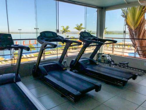 巴西利亚Belo Flat Resort Lake Side Beira Lago的窗户前设有两个跑步机的健身房