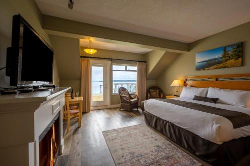 悉尼Sidney Waterfront Inn & Suites的酒店客房设有床、电视和窗户。