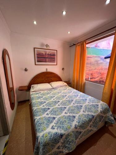 伊基克Hotel Casa del profesor Iquique的一间卧室设有一张床和一个窗口