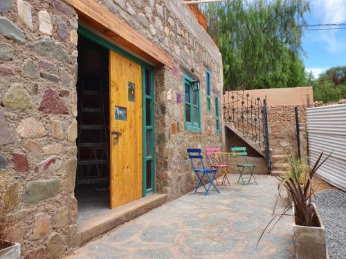 蒂尔卡拉La Llama Negra的石头房子,设有配有椅子和桌子的庭院