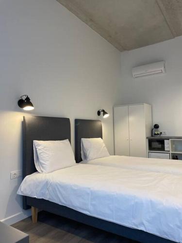 克雷廷加Apartment Loftas13-5的卧室配有一张带两个枕头的大白色床