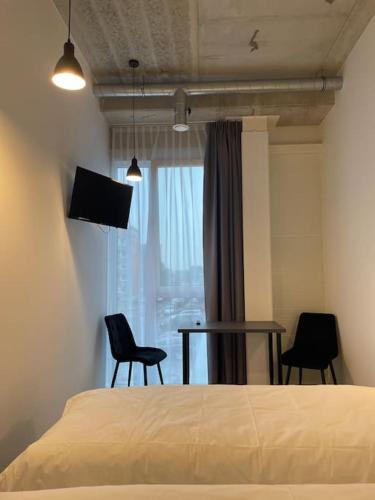 克雷廷加Apartment Loftas13-5的一间卧室配有一张床、两把椅子和一张桌子
