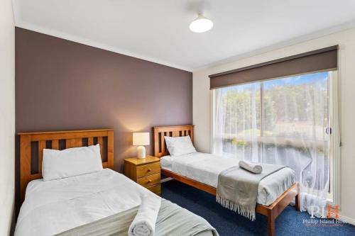 卡尔斯Phillip Island Family Resort 2Bdr的带窗户的客房内的两张床