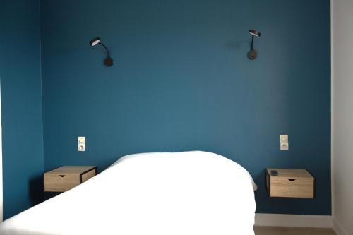 Couhé-VeracRELAIS 375的一间卧室设有蓝色的墙壁和一张带两个箱子的床