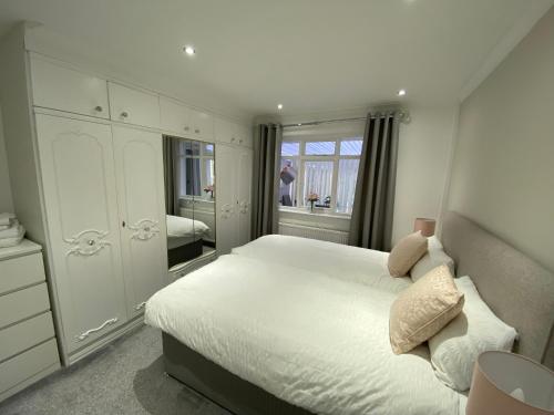 ThorntonCOLERIDGE LODGE的卧室配有白色的床和镜子