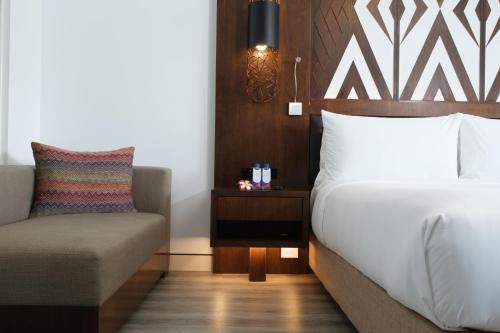 南迪Crowne Plaza Fiji Nadi Bay Resort & Spa, an IHG Hotel的配有一张床和一把椅子的酒店客房