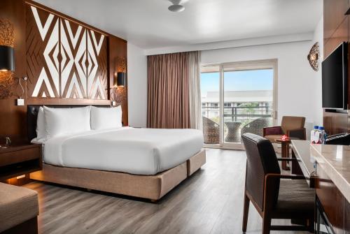 南迪Crowne Plaza Fiji Nadi Bay Resort & Spa, an IHG Hotel的配有一张床、一张书桌和一扇窗户的酒店客房