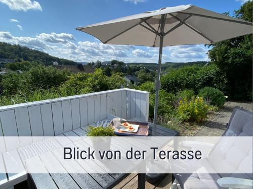 施马伦贝格Ferienhaus Dackelglück的一张带雨伞和一碗食物的野餐桌
