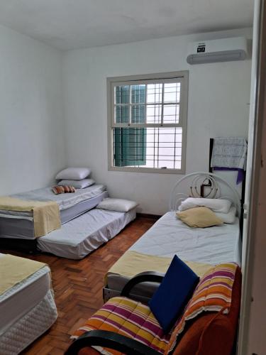 圣保罗Casa Térrea SP Expo e C Paralimpico的带三张床和窗户的客房