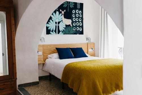 阿尔科斯-德拉弗龙特拉Botánico Casa Rural的一间卧室配有一张带蓝色枕头的床