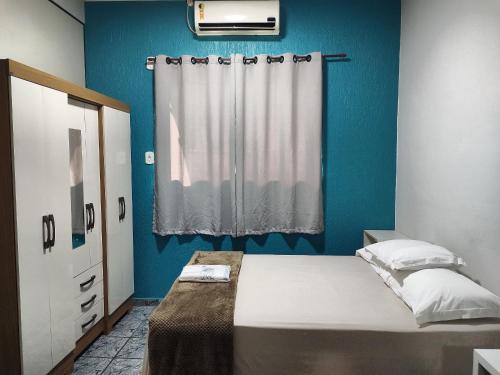 卡夸尔Apartamentos aconchegantes no centro da cidade的蓝色的卧室设有床和窗户