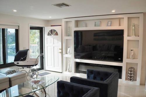 达尼亚滩Stylish home的客厅配有玻璃桌和电视
