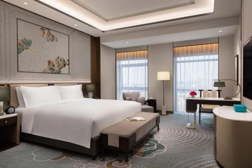 保定雄安索菲特酒店的酒店客房设有一张大床和一张书桌。