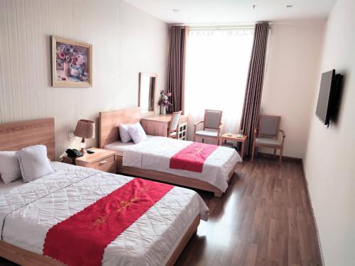 海防Nhà Khách Hương Sen的酒店客房设有两张床和电视。