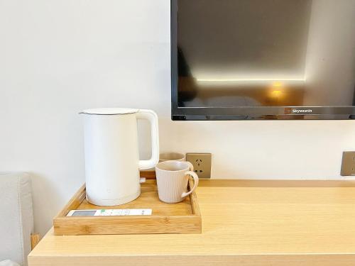 凤凰凤凰古城Hemu House的一张桌子、两个咖啡杯和一台电视机